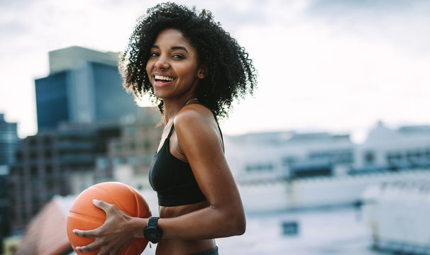 Portrait of a fitness woman holding a basketball