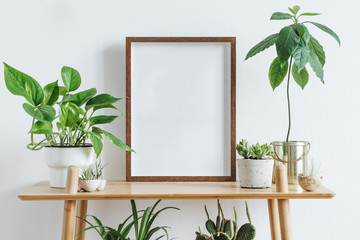 Scandinavian room interior with mock up photo frame on the brown bamboo shelf with beautiful plants...