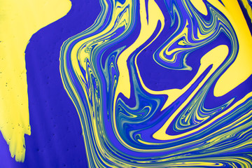 Abstract painting background in vivid colors. Marbleized bright effect with fluid painting, background for wallpapers, poster, postcard. Swirls and lines with yellow and blue. Pop crazy colors