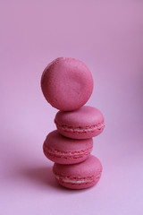 Fototapeta na wymiar Four pink macaroons on a light pink background, sweet minimal food concept
