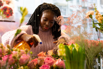 Cheerful international florist taking care of roses