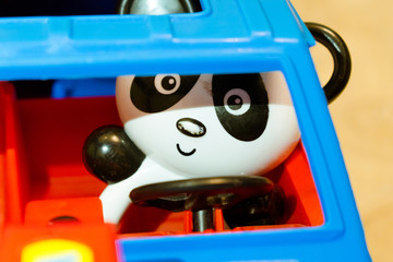 Toy plastic panda driving a car