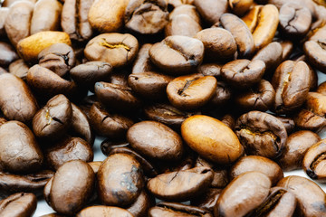 Many coffee beans on a pile, colored macro shot..