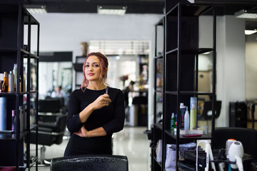 Beautiful young hairdresser in beauty salon