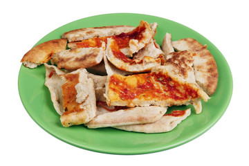 Slices of dried Italian pizza on a green plate isolated