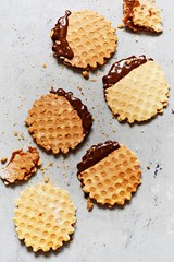 Dutch waffles with salted caramel,Dutch waffles with salted caramel, nuts and black chocolate on a gray background. Delicious crunchy dessert. Flat lay