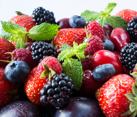 Obraz premium Ripe strawberries, blackberries, blueberries, raspberries, red berries abd plum. Mix berries and fruits. Top view. Background berries and fruits. Black-blue and red berries and fruits.
