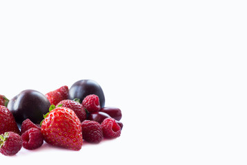 Fruits and berries isolated on white background. Ripe raspberries, strawberries, red berries and plums. Background of mix fruits with copy space for text. Mix berries on white background.