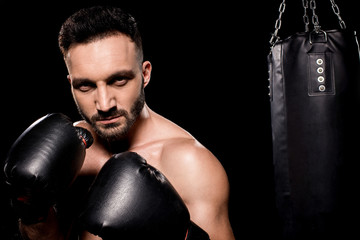 sportsman wearing boxing gloves standing in boxing pose isolated on black