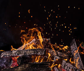 Flaming Logs, fire flames with sparks flying in the air, close-up.