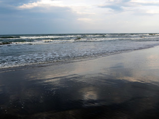 Clouds are reflected in surf waves, Rimini,  Italy, Adriatic sea.