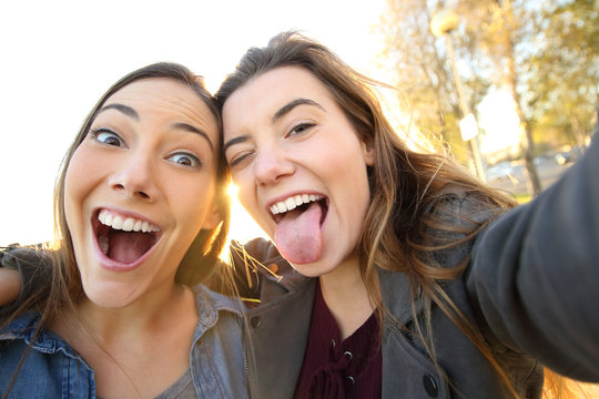 Funny women joking taking selfies in the street