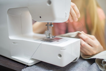 Woman working with the machine for sewing. Woman push through a rope into the needle sewing machine. Sewing Process