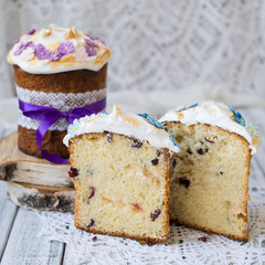 Slice of easter orthodox sweet bread, kulich on wooden background with floral fabric. Retro style. Breakfast. Close up, selective focus, copy space.
