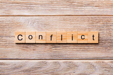 CONFLICT word written on wood block. CONFLICT text on wooden table for your desing, concept