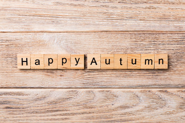 Happy autumn word written on wood block. Happy autumn text on wooden table for your desing, concept