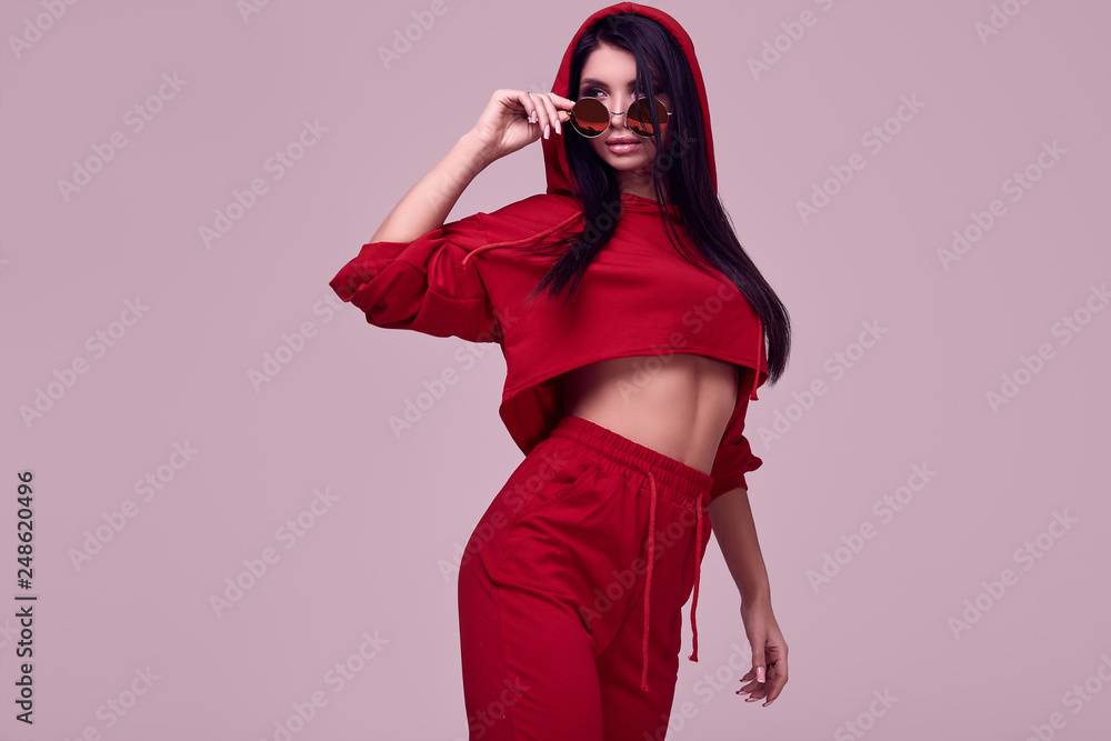 Wall mural Gorgeous brunette woman in fashion red hoodie in studio