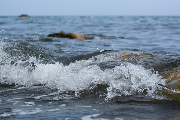 The wave breaks on the rock and forms a lot of spray