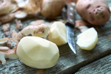 Potato peeling on the rough wooden boards of a country table