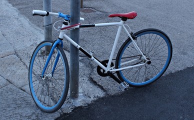 Fototapeta na wymiar Italy: Bike tied to the pole.