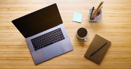 Creative Professional Workspace. Workplace Aerial Top View. Modern Wooden Table Desk with Laptop, Coffee Mug, Notepad, Lamp, Sketchbook, Pencil, Sticky Notes. Flat Lay.