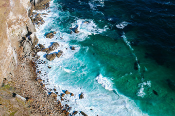 Background texture of a rocky shore and blue and turquoise water and waves of the Atlantic Ocean at the Cape of Good Hope in South Africa © Anna