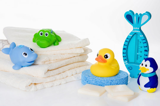 Still life with baby hygiene and bath items,  baby soap, towel,  rubber toy, shower puff, thermometer