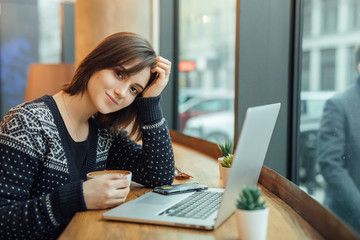 Woman Look Around And Smile While Work In Cafe On Her Laptop. Portrait Of Stylish Smiling Woman In Winter Clothes Work At Laptop. Female Bussiness Style With Sun. - Image