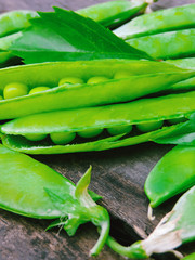 Fresh green peas on wood background.  peas, pods and leaves set. Healthy food. Macro shooting. Flower, green leaves,top view, flat lay.Branches of ripe, green peas.Green Pea High in Vitamin K, B.