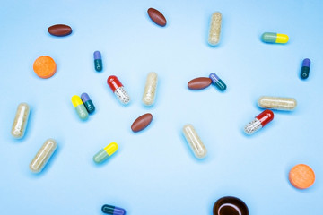 Different pills on a blue background. A photo of different medical drugs, tablets and pills on blue background Pretty pills.