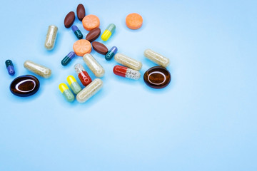 Different pills on a blue background. A photo of different medical drugs, tablets and pills on blue background Pretty pills.