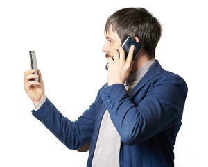 male businessman with a beard with two phones, talking on one phone, looking at the second phone