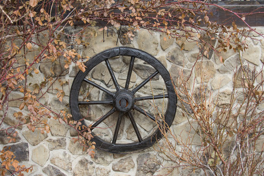 Old wooden wheel on the wall ,autumn