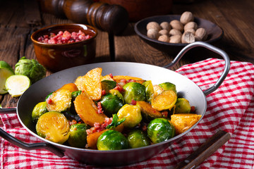 Brussels sprouts potato pan with bacon in rustic style