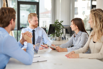 Small group of business people sitting at table and having meeting. Multi cultural group.