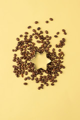 Star shape in coffee beans on yellow background