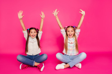 Close up photo two little age she her girls hands arms up best friends sit floor legs crossed...