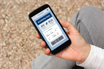 Hand holding smart phone with boarding pass concept on screen