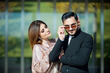 Young beautiful couple standing in the Park on the background of a modern building.