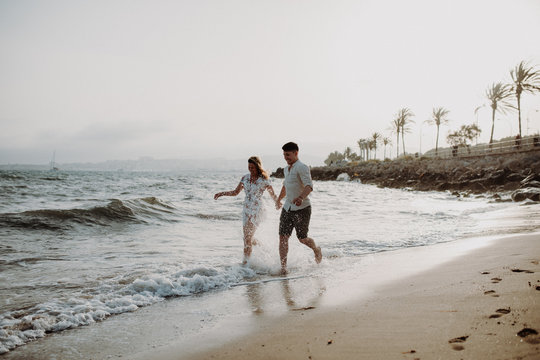 Paar rennt am Strand Hand in Hand