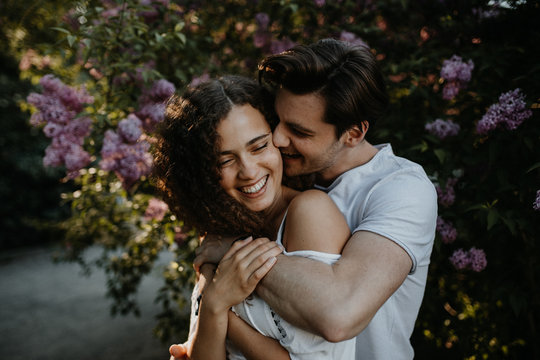 verliebtes Paar vor blumigem Hintergrund im Park