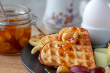 Easter breakfast. served in a rustic style. waffles, slices of ripe fresh fruit. selective focus.