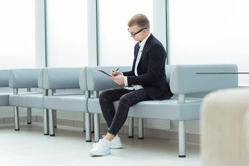 businessman reading a business document sitting in the office lobby