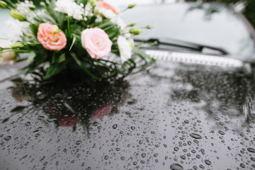 A car front decorated with flowers on wedding day close up