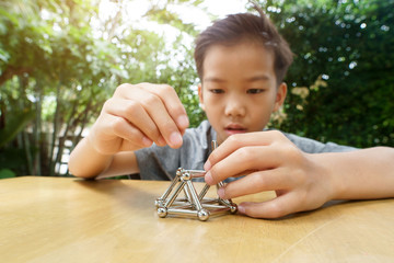 Young boy play a  stick and magnetic ball