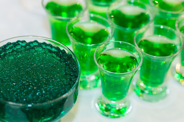 vivid green cocktails with molecular caviar close up, glowing drinks of the fluorescent bar.
