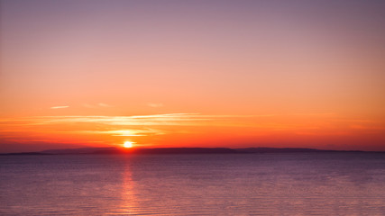Fototapeta na wymiar Beautiful Sunrise over the Sea and Sky in Magenta Colors