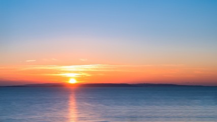 Long Exposure Sunrise over a Blue Sea with Silky Smooth Water