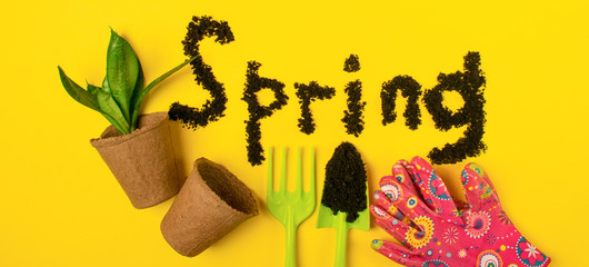 The text of the word spring is laid out on a yellow spring background with various garden accessories and tools.