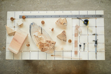 High angle view of carpenters desk with hand tools for technical measurements and wooden pieces used for assembling toys